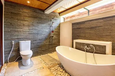 a bathroom with a tub and a toilet at Cove Urbanest Inn in Seminyak