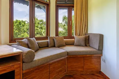 a couch sitting in front of a window at Cove Urbanest Inn in Seminyak
