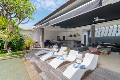 a patio with white chairs and a living room at Gorgeous Tropical 3 Bed Pool Villa, 24hr Security in Seminyak