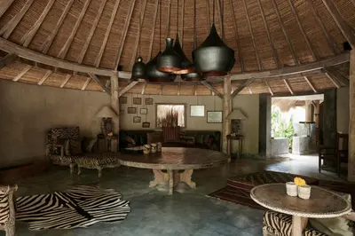 a living room with a table and some chairs at The Island Houses Seminyak in Seminyak