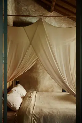 a bedroom with a canopy bed with white pillows at The Island Houses Seminyak in Seminyak