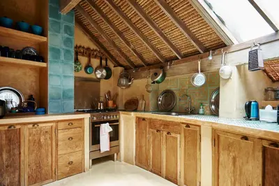 a large kitchen with wooden cabinets and a counter top at The Island Houses Seminyak in Seminyak