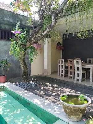 a tree in front of a house with a pool at Room Valka Bali Seminyak in Seminyak
