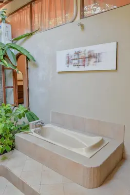 a bathroom with a bath tub in a room at Ben Bali Villa in Seminyak