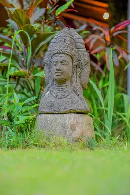 a statue of a woman sitting in the grass at Ben Bali Villa in Seminyak