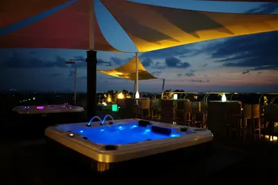 a jacuzzi tub sitting on top of a balcony at night at Hotel Daun Bali Seminyak in Seminyak