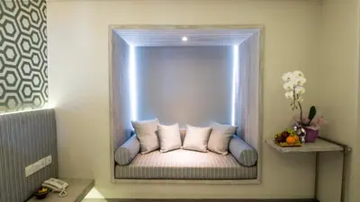 a bed in a room with a mirror at Hotel Daun Bali Seminyak in Seminyak