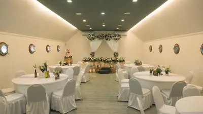 a banquet hall with white tables and chairs at Hotel Daun Bali Seminyak in Seminyak