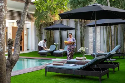 a woman standing in a yard with an umbrella at Best Location, 9 Bedr Pool Villa, Close To Beach in Seminyak