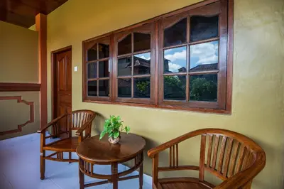 a room with two chairs and a table and a window at Suka Beach Inn in Kuta