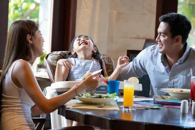 a group of people sitting around a table eating food at Holiday Inn Resort Bali Nusa Dua by IHG in Nusa Dua