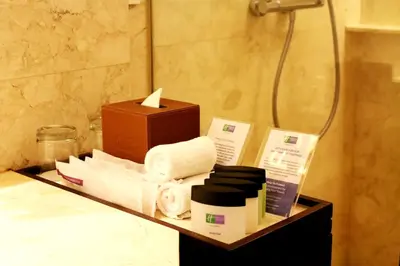 a bathroom with a shelf with towels and a shower at Holiday Inn Resort Bali Nusa Dua by IHG in Nusa Dua