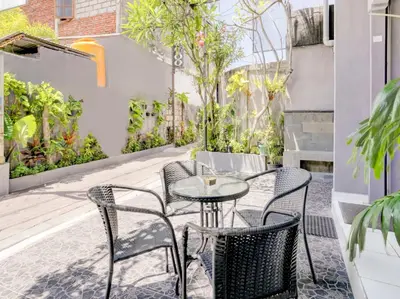 an outdoor patio with a table and chairs at Paradise Inn in Legian