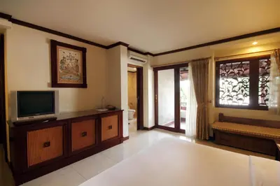 a living room with a television and a window at Grand Balisani Suites Hotel in Seminyak