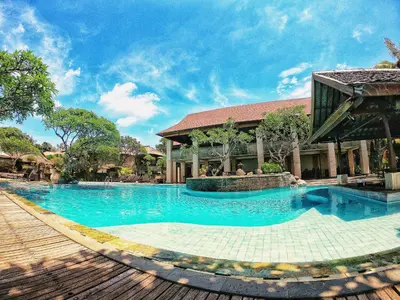 a large swimming pool in front of a building at Grand Balisani Suites Hotel in Seminyak