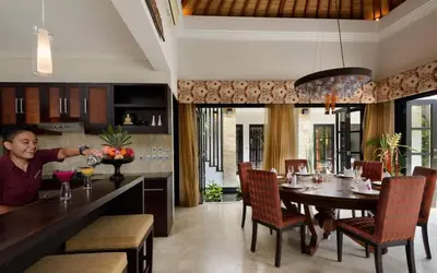 a man in a kitchen with a table in a room at The Residence Seminyak in Seminyak