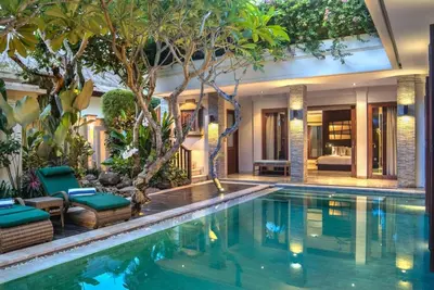a swimming pool in a villa with a house at The Residence Seminyak in Seminyak