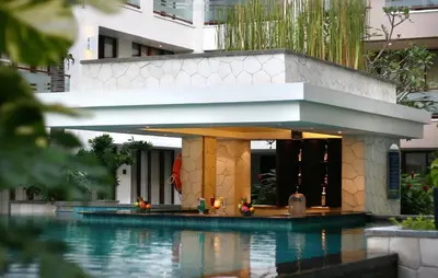 a swimming pool in front of a building at Aston Kuta Hotel and Residence in Kuta