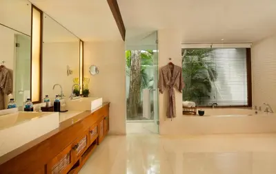 a bathroom with two sinks and a tub and a shower at The Legian Seminyak, Bali in Seminyak