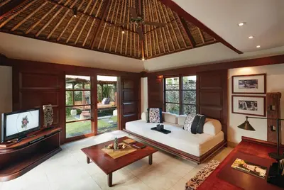 a living room with a couch and a tv at Jimbaran Puri, A Belmond Hotel, Bali in Jimbaran