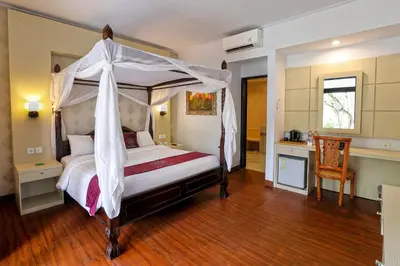 a bedroom with a large bed with a canopy at Puri Saron Hotel Seminyak in Seminyak