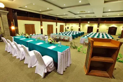 a room with long tables and chairs and a podium at Puri Saron Hotel Seminyak in Seminyak