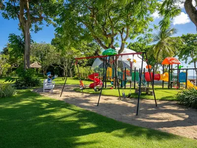 a park with a playground in the grass at Discovery Kartika Plaza Hotel in Kuta