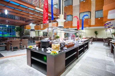 a buffet in a restaurant with tables and chairs at Famous Hotel Kuta Formerly Permata Kuta Hotel in Kuta