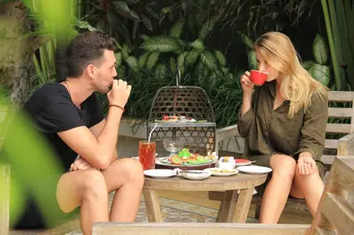 a man and a woman sitting at a table drinking coffee at The Wolas Villas in Seminyak