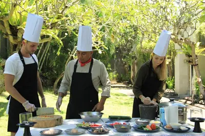 a group of people in chefs hats preparing food at The Wolas Villas in Seminyak