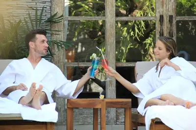 a man and woman in white robes playing with a pair of scissors at The Wolas Villas in Seminyak