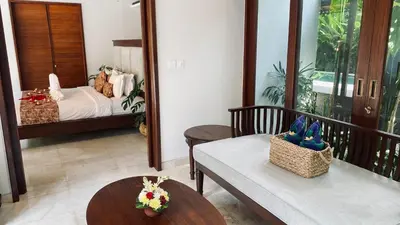 a room with a balcony with a bed and a table at Aria Exclusive Villas & SPA in Seminyak