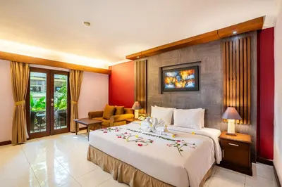 a hotel room with a large bed with flowers on it at Risata Bali Resort & Spa in Kuta