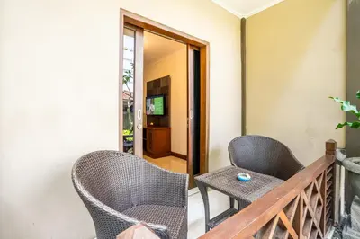 a balcony with chairs and a television in a room at Risata Bali Resort & Spa in Kuta