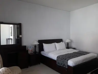 a hotel room with a bed and a mirror at The Radiant Hotel in Kuta