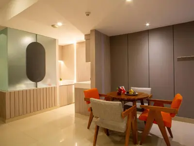 a dining room with a wooden table and chairs at HARRIS Hotel & Residences Riverview Kuta, Bali in Kuta