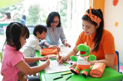 a group of children sitting at a table at HARRIS Hotel & Residences Riverview Kuta, Bali in Kuta