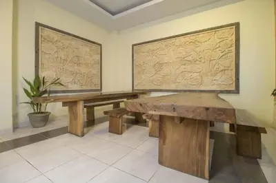 two wooden benches in a room with a wall at RedDoorz at Benesari 2 Legian in Kuta