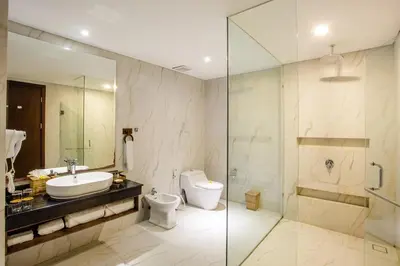 a bathroom with a sink and a toilet and a shower at Jimbaran Bay Beach Resort and Spa by Prabhu in Jimbaran