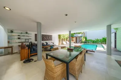 a living room with a glass table and a swimming pool at Villa Rio - Contemporary 2BR Villa in Downtown Seminyak in Seminyak