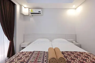 a bedroom with a white bed with towels on it at Pondok Nyaman 15 in Denpasar