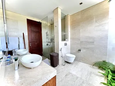 a bathroom with two sinks and a toilet and a shower at Villa Meliya in Canggu