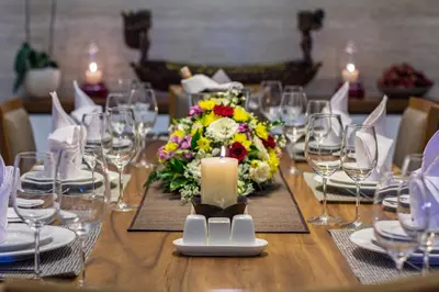 a table with a candle and a bouquet of flowers at Villa Meliya in Canggu