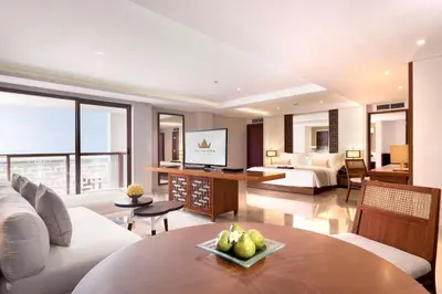 a living room with a couch and a bed and a table at The Bandha Hotel & Suites in Legian