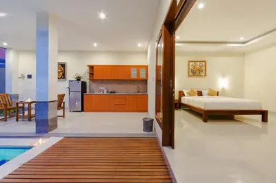 a bedroom and kitchen with a bed and a swimming pool at Paisa Villa Seminyak in Seminyak