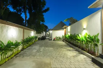 a cobblestone alley with plants on the side of a building at Paisa Villa Seminyak in Seminyak