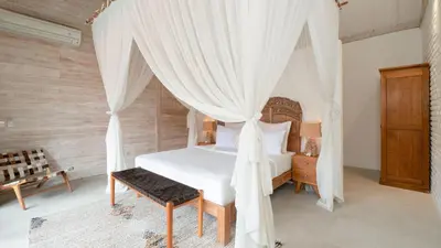 a bedroom with a white bed with a canopy at Villa Taramille by Villa Finder in Kerobokan