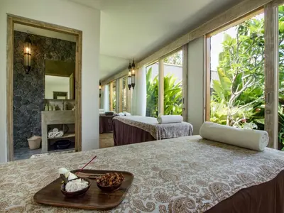 a bedroom with a bed with a tray of food on it at Villa Mannao by Villa Finder in Kerobokan