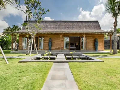 a log house with a garden and a patio at Villa Mannao by Villa Finder in Kerobokan