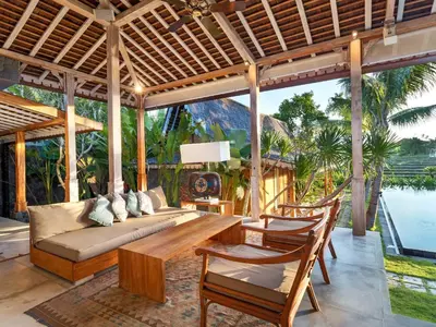 a living room with a couch and a table and chairs at Villa Mannao by Villa Finder in Kerobokan